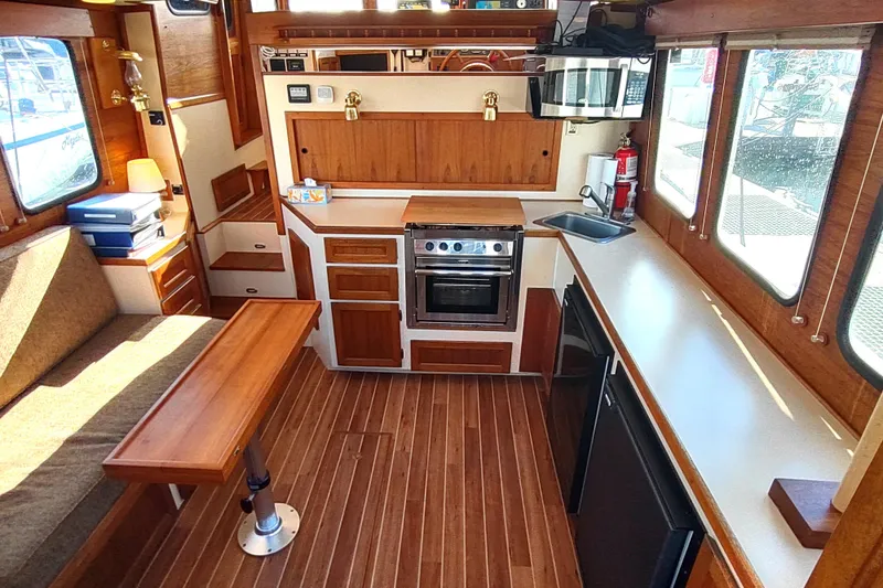 Slide: The Image of Interior of 1990 Nordic Tug 32 with wood finish, kitchen, and seating area. - 18