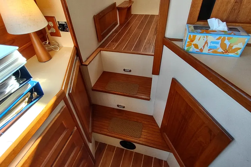 Slide: The Image of Interior of a 1990 Nordic Tug 32, featuring wooden steps and cozy decor. - 24