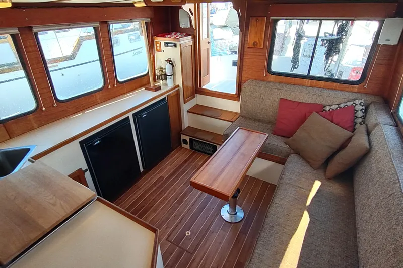 Slide: The Image of Interior of 1990 Nordic Tug 32 with kitchenette, windows, and safety equipment. - 28