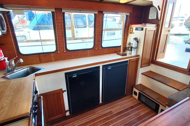 Slide: The Image of Interior of a 1990 Nordic Tug 32, featuring cozy seating and wooden accents. - 29