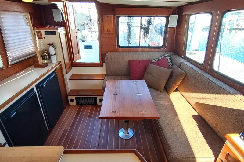 Slide: The Image of Interior of a 1990 Nordic Tug 32, featuring a compact kitchen with wooden accents. - 30