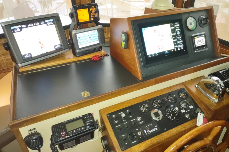 Slide: The Image of 1990 Nordic Tug 32 helm with navigation equipment and wooden steering wheel. - 35