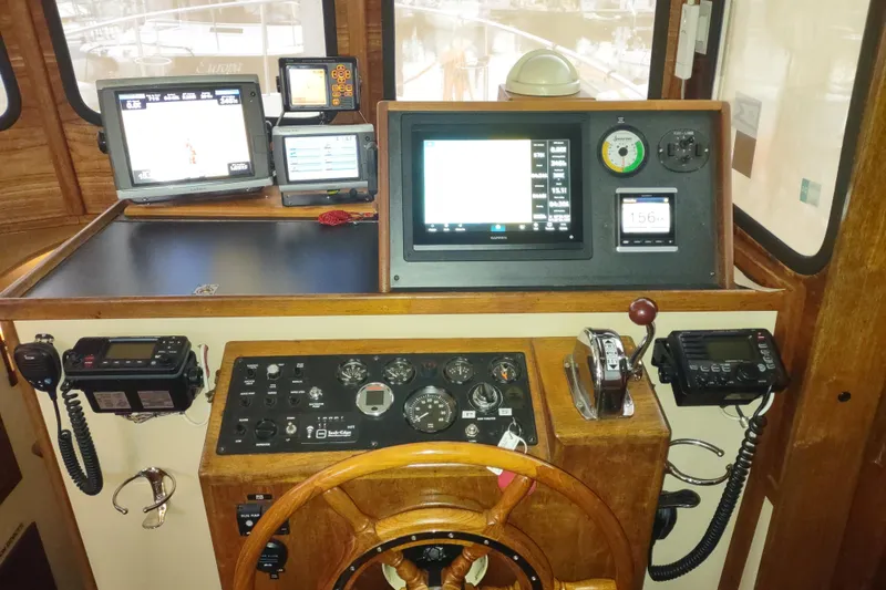 Slide: The Image of 1990 Nordic Tug 32 helm with navigation equipment and wooden steering wheel. - 38