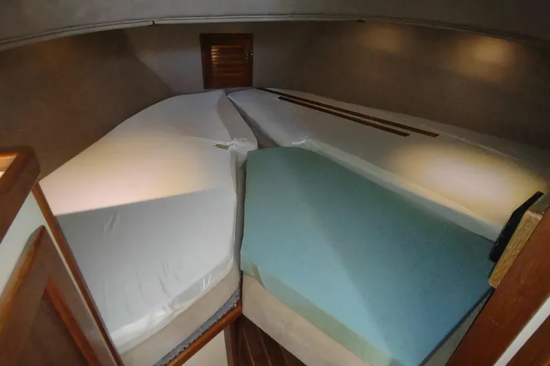 Slide: The Image of 1990 Nordic Tug 32 interior cabin with wooden finish and cozy sleeping area. - 45