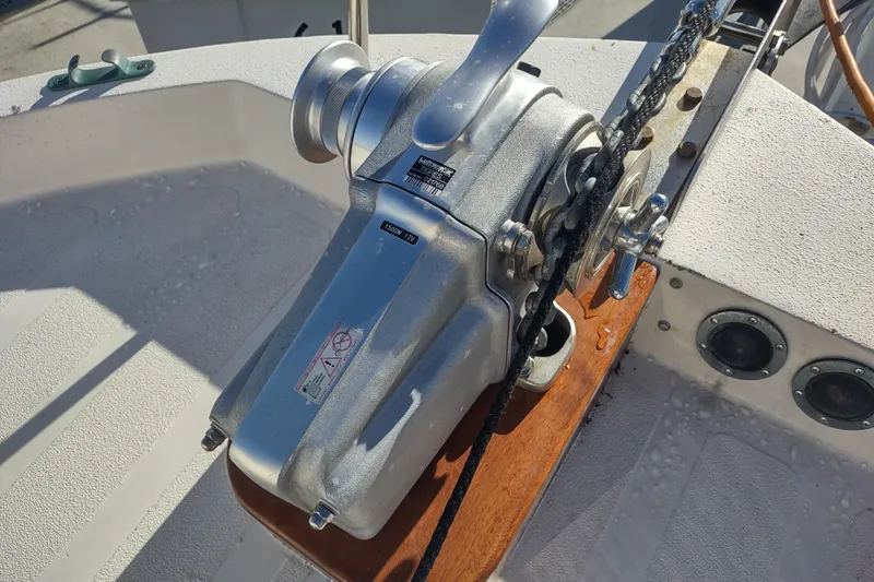 Slide: The Image of 1990 Nordic Tug 32 docked, featuring anchor and mooring lines in a marina setting. - 55