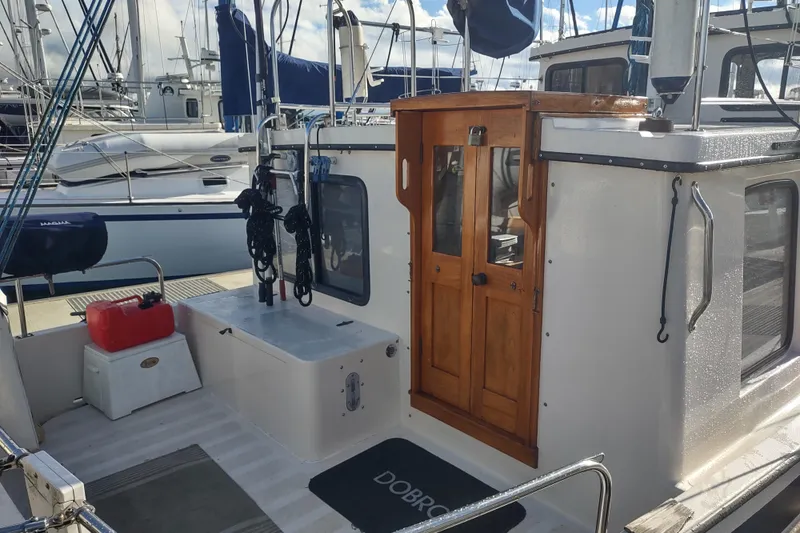Slide: The Image of 1990 Nordic Tug 32 boat with wooden door and deck, docked at marina. - 9