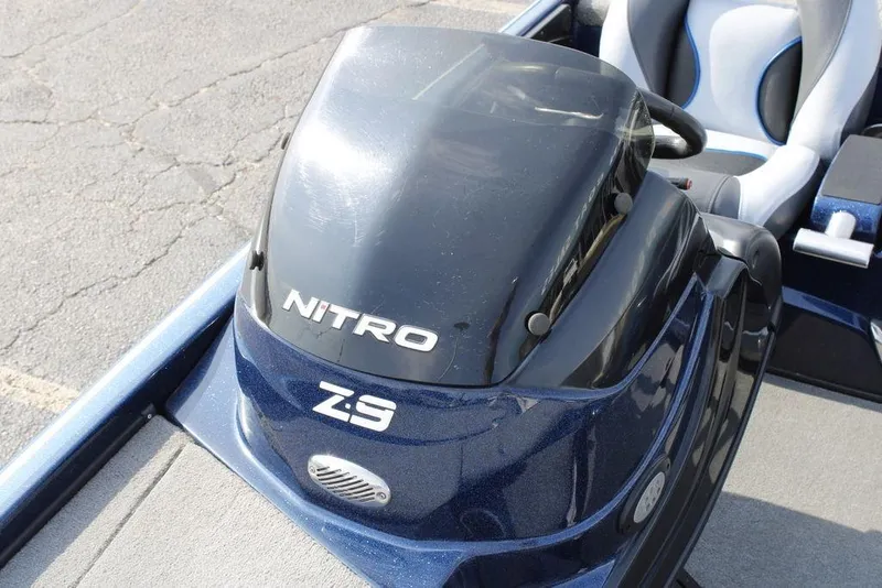 Slide: The Image of 2015 Nitro Z-9 boat console with steering wheel and seat, parked on pavement. - 15
