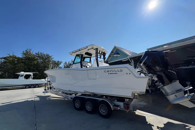 Slide: The Image of 2026 Caymas 30 CT boat on trailer under clear blue sky. - 15
