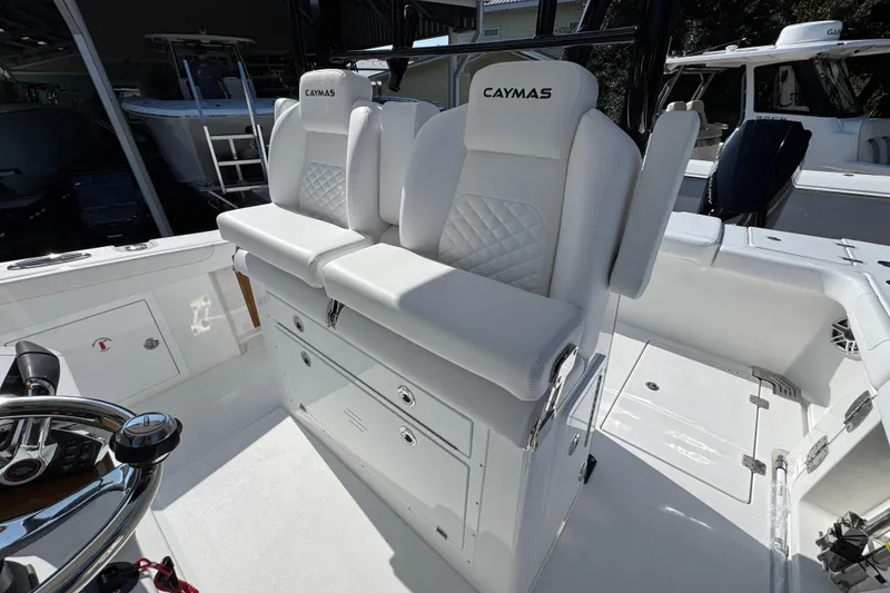 Slide: The Image of 2026 Caymas 30 CT boat interior with white cushioned seating and steering wheel. - 26
