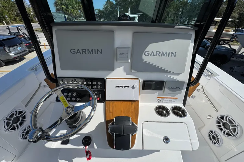 Slide: The Image of 2026 Caymas 30 CT boat dashboard with Garmin displays and Mercury controls. - 30