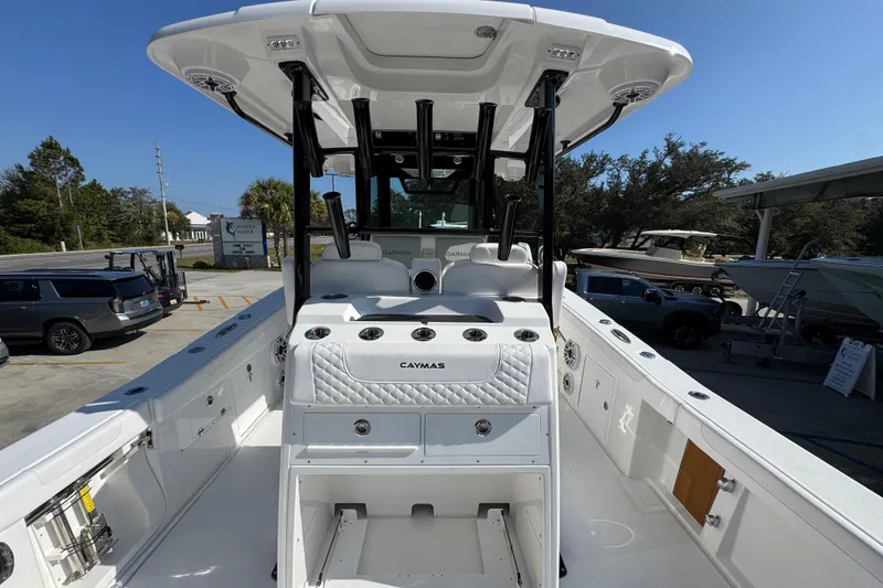 Slide: The Image of 2026 Caymas 30 CT boat interior with seating and storage, parked outdoors. - 37