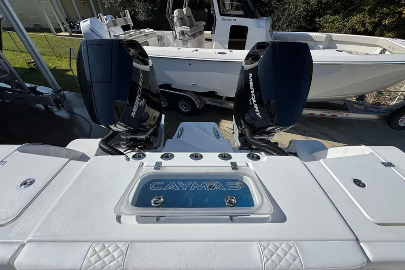 Slide: The Image of 2026 Caymas 30 CT boat with dual Mercury engines, docked on a trailer. - 41