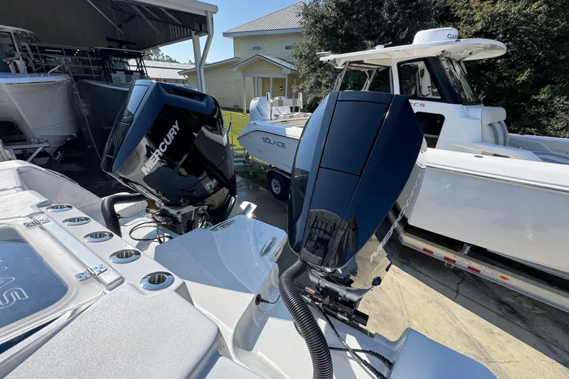 Slide: The Image of 2026 Caymas 30 CT boat with dual Mercury outboard engines, docked near other boats. - 42