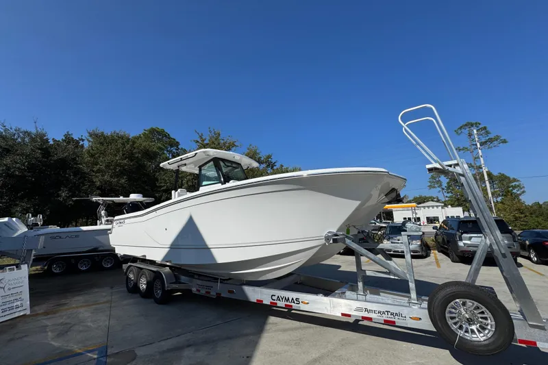 Slide: The Image of 2026 Caymas 30 CT boat on trailer, parked outdoors under clear blue sky. - 8