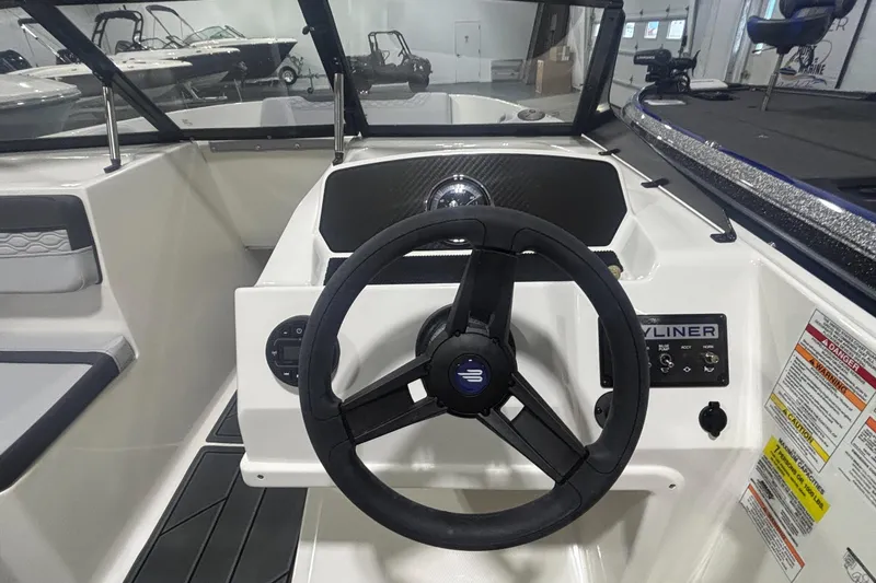 Slide: The Image of 2026 Bayliner M17 boat dashboard with steering wheel and control panel. - 6