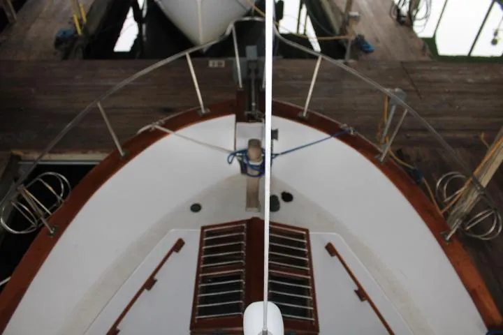 Slide: The Image of 1976 CHB Double Cabin Trawler bow view at dock, showcasing deck and railing. - 11