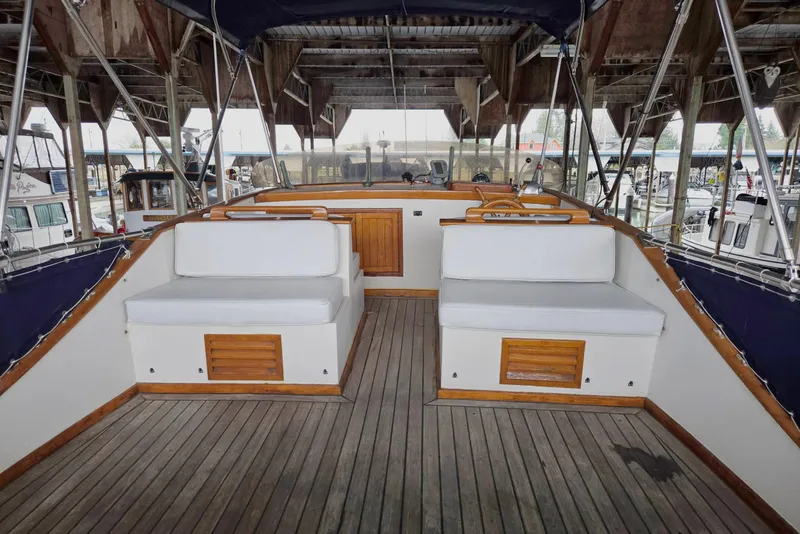 Slide: The Image of 1976 CHB Double Cabin Trawler interior with wooden deck and cushioned seating. - 13