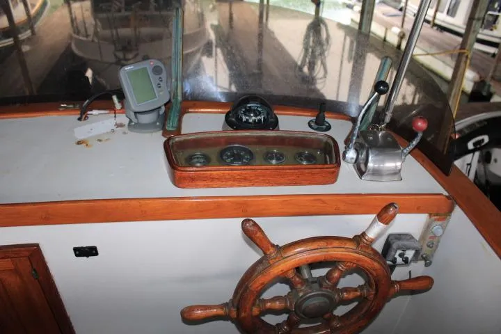 Slide: The Image of 1976 CHB Double Cabin Trawler helm with wooden wheel and navigation instruments. - 16