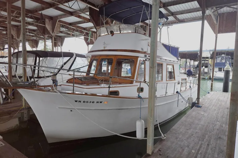 Slide: The Image of 1976 CHB Double Cabin Trawler docked in a covered marina. - 2