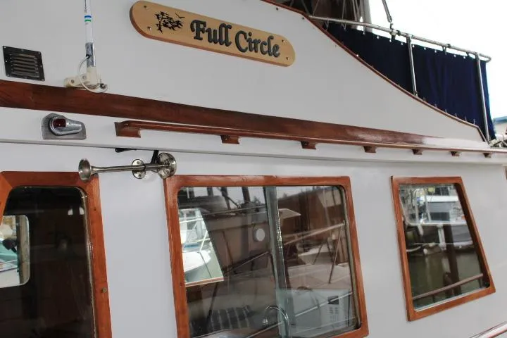 Slide: The Image of 1976 CHB Double Cabin Trawler "Full Circle" with wooden trim and docked in a marina. - 23