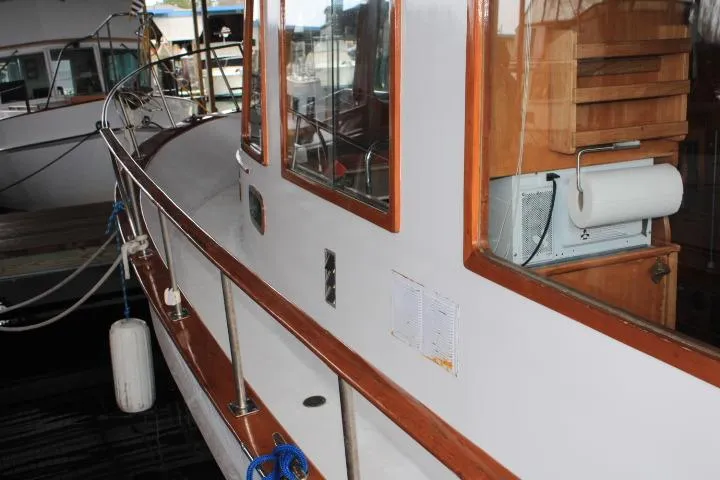Slide: The Image of 1976 CHB Double Cabin Trawler with wooden trim, docked at a marina. - 24