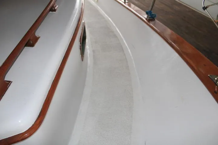 Slide: The Image of 1976 CHB Double Cabin Trawler deck with wooden trim and clean white surface. - 27