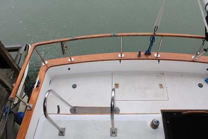 Slide: The Image of 1976 CHB Double Cabin Trawler deck with wooden railings and metal fixtures. - 29