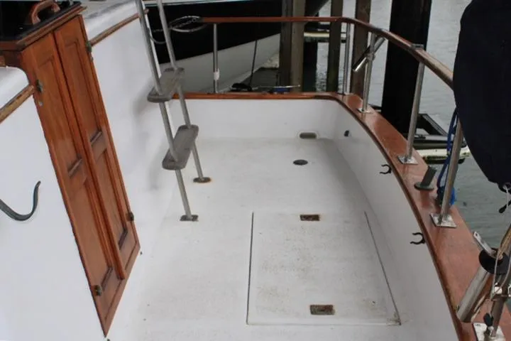 Slide: The Image of 1976 CHB Double Cabin Trawler deck with wooden accents and ladder. - 31