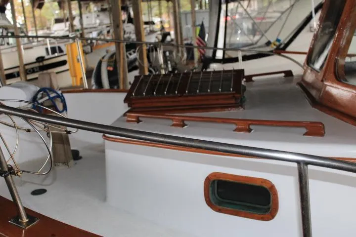 Slide: The Image of 1976 CHB Double Cabin Trawler with wooden accents in a marina setting. - 36