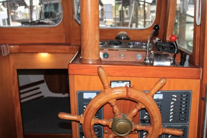 Slide: The Image of 1976 CHB Double Cabin Trawler helm with wooden wheel and control panel. - 42
