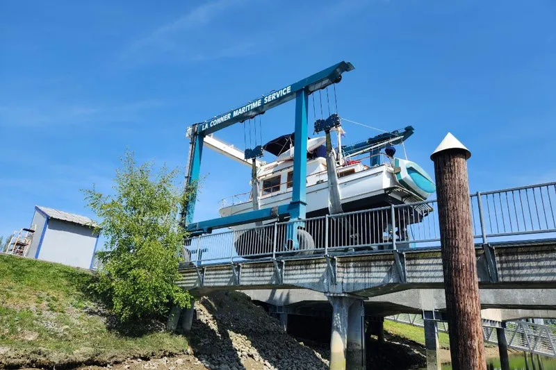 Slide: The Image of 1976 CHB Double Cabin Trawler lifted by La Conner Maritime Service under clear blue sky. - 5