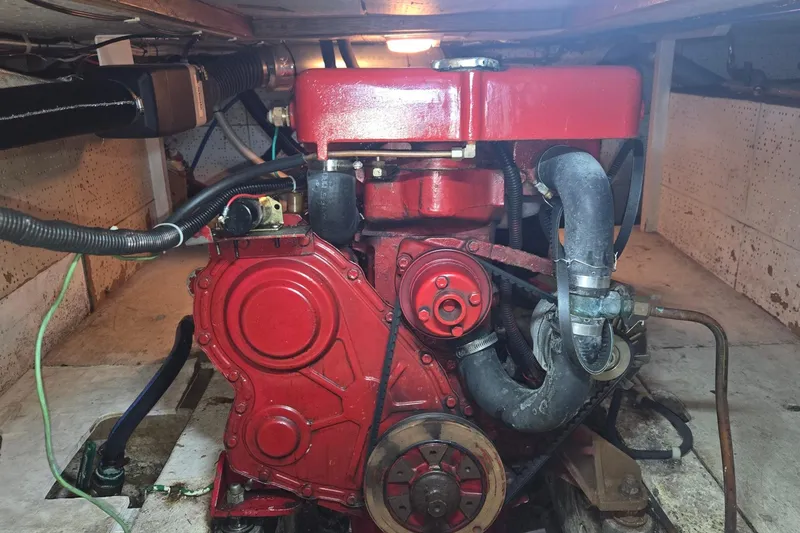 Slide: The Image of Red engine inside a 1976 CHB Double Cabin Trawler, showcasing mechanical components. - 53