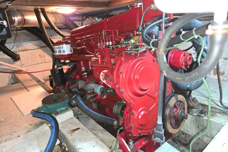 Slide: The Image of Engine room of a 1976 CHB Double Cabin Trawler with red machinery components. - 54