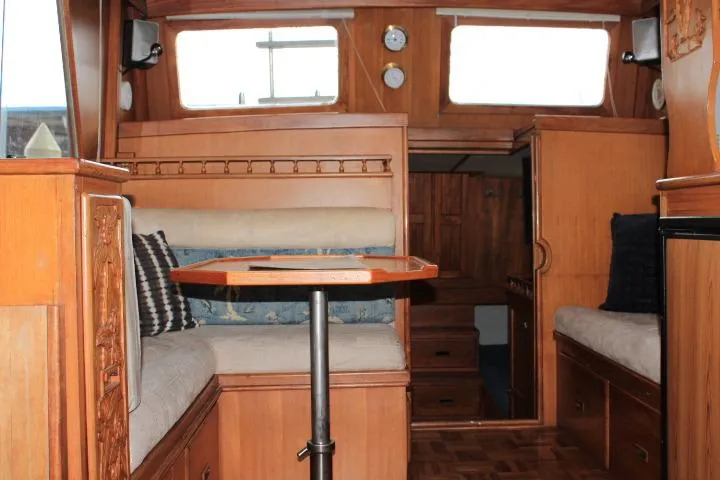 Slide: The Image of Interior of a 1976 CHB Double Cabin Trawler with wooden furnishings and seating area. - 61