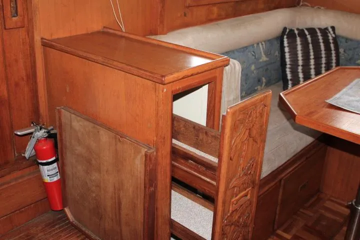Slide: The Image of 1976 CHB Double Cabin Trawler interior with wooden furniture and seating area. - 67