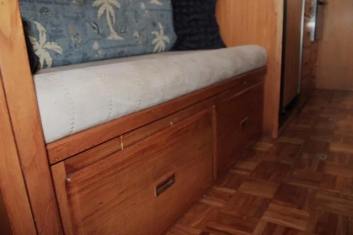 Slide: The Image of 1976 CHB Double Cabin Trawler interior with wooden storage bench and patterned cushion. - 69