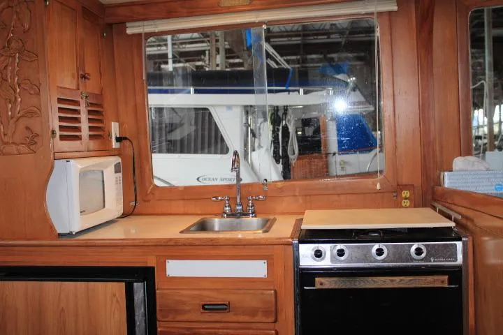 Slide: The Image of 1976 CHB Double Cabin Trawler kitchen with sink, stove, and microwave. - 70