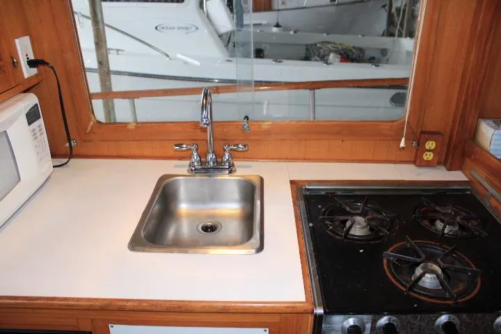 Slide: The Image of 1976 CHB Double Cabin Trawler kitchen with sink, stove, and microwave. - 71
