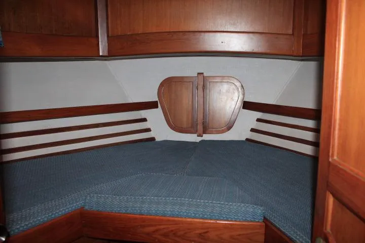 Slide: The Image of 1976 CHB Double Cabin Trawler interior with wooden finish and blue bedding. - 75
