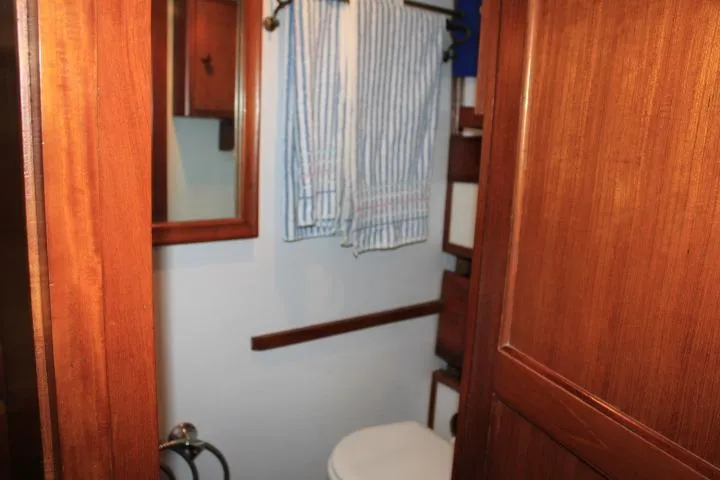 Slide: The Image of 1976 CHB Double Cabin Trawler bathroom with wooden cabinetry and striped towels. - 77