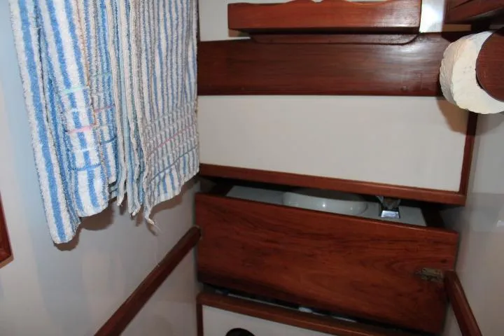 Slide: The Image of 1976 CHB Double Cabin Trawler interior with wooden cabinets and striped towels. - 78