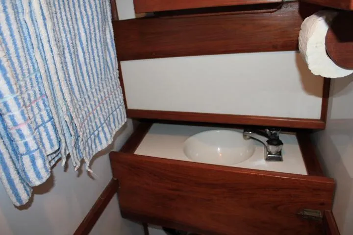 Slide: The Image of 1976 CHB Double Cabin Trawler bathroom with wooden cabinetry and sink. - 79