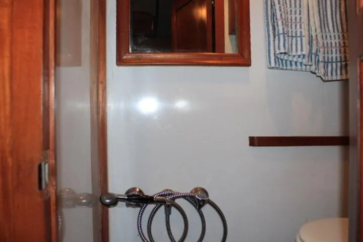 Slide: The Image of 1976 CHB Double Cabin Trawler bathroom with mirror, towel, and shower fixtures. - 80