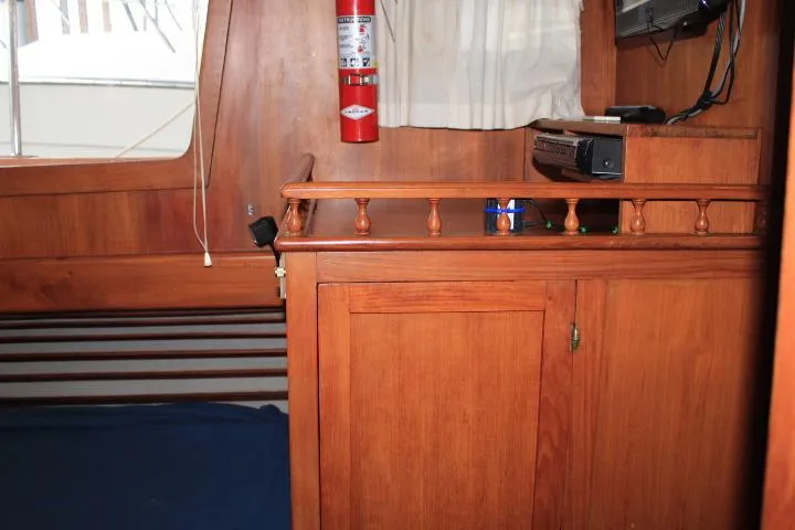 Slide: The Image of 1976 CHB Double Cabin Trawler interior with wooden cabinetry and fire extinguisher. - 90