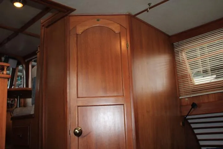Slide: The Image of 1976 CHB Double Cabin Trawler interior with wooden paneling and door. - 92