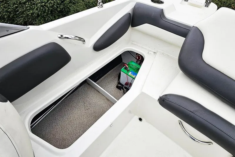 Slide: The Image of 2019 Stingray 191 DC boat interior with open storage compartment and battery. - 11