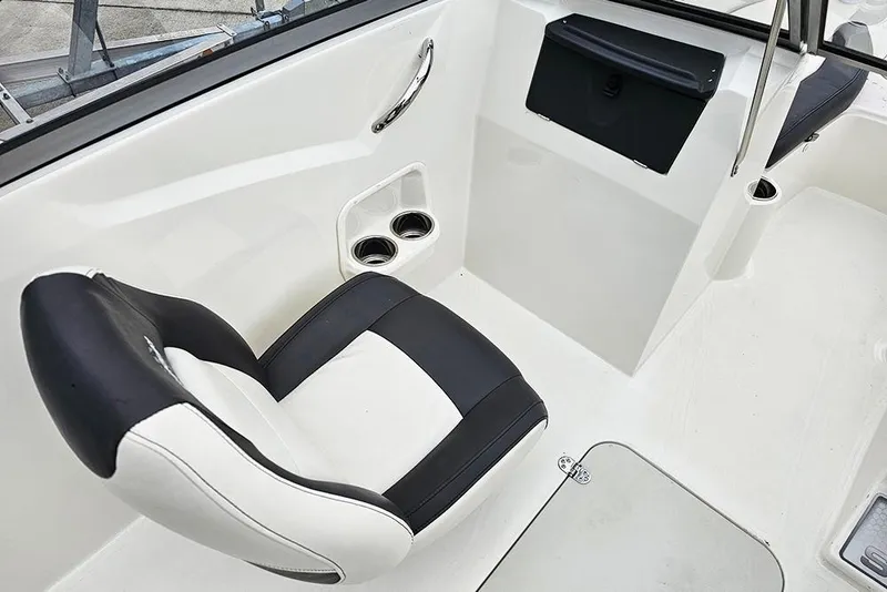 Slide: The Image of 2019 Stingray 191 DC boat interior with black and white seating and cup holders. - 14