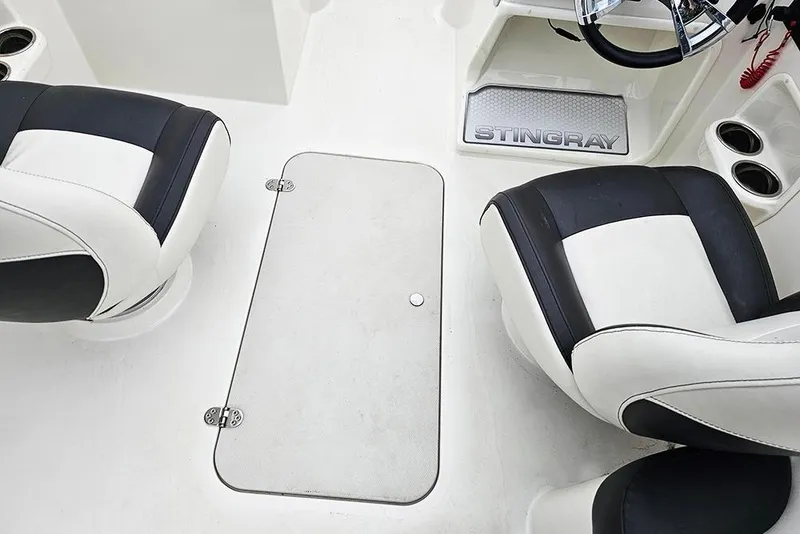 Slide: The Image of 2019 Stingray 191 DC boat interior with black and white seats and Stingray branding. - 19