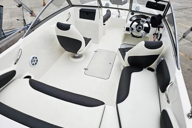 Slide: The Image of 2019 Stingray 191 DC boat interior with black and white seating and steering wheel. - 9