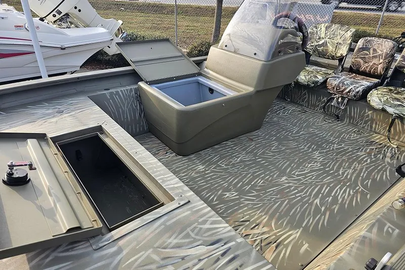 Slide: The Image of 2024 Tracker Grizzly 1754 SC boat interior with camo seats and storage compartments. - 10